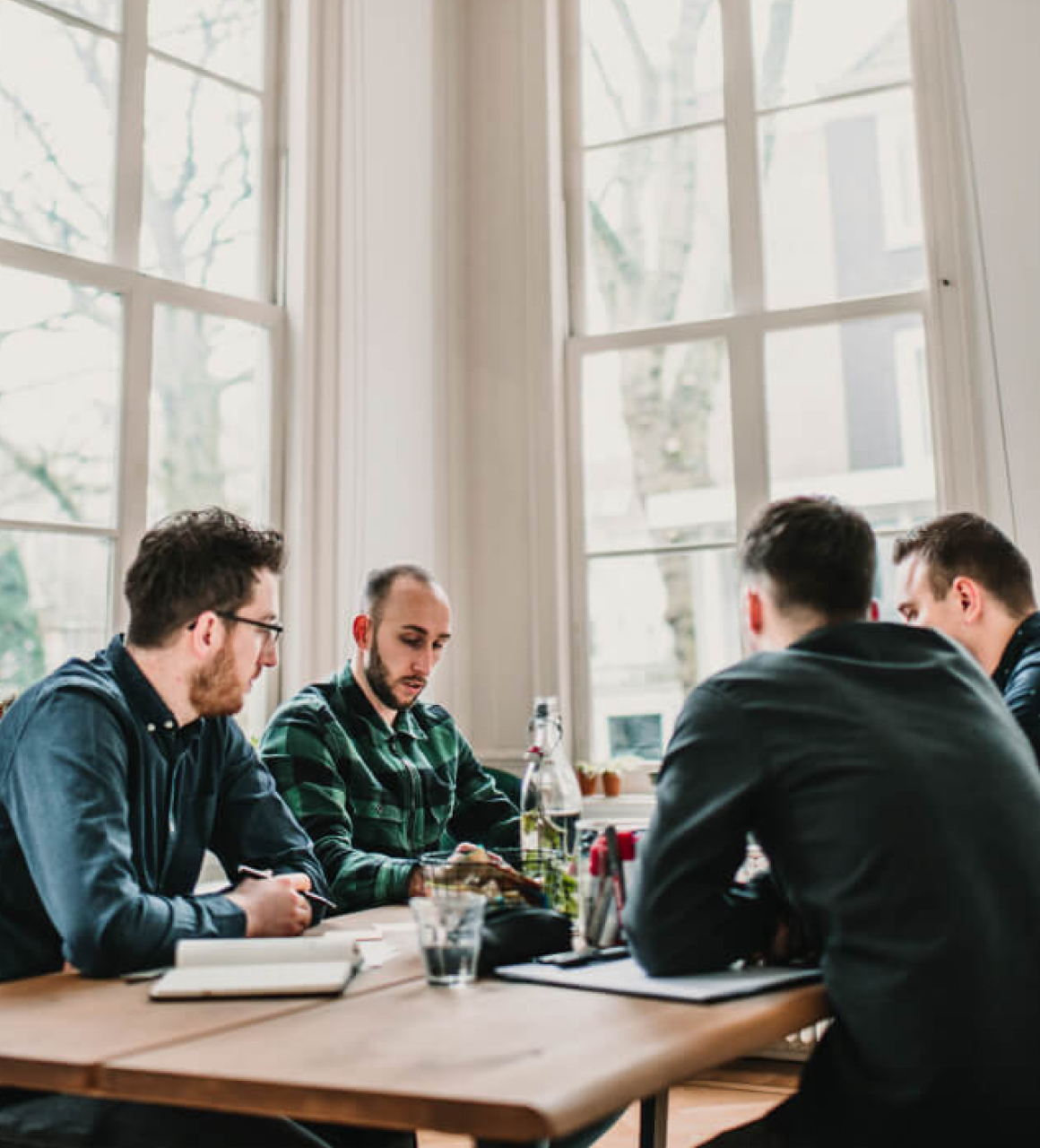 Simon van Acht in gesprek met collega's rond een werktafel